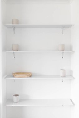 Minimalist beyaz duvar rafları beyaz saksıları ve ahşap tepsileri olan bir oyuk, modern iç tasarım konsepti ve basit ev geliştirmeleri