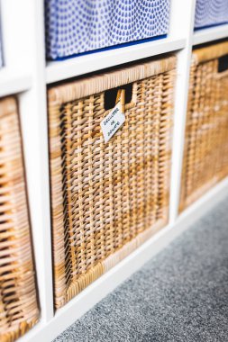 Üzerinde Declutter ya da Bağış etiketi olan sepetin üzerinde odaklanmamış depolama dolabı ve arka plandaki diğer sepetler, evinizi küçültme ve düzenleme kavramı