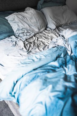 dağınık ve dağınık görünümlü, açık mavi yorgan ve çarşaflı kraliçe yatağı uykunuzu veya çift yaşam konseptinizi geliştirir.