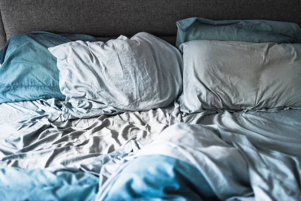 dağınık ve dağınık görünümlü, açık mavi yorgan ve çarşaflı kraliçe yatağı uykunuzu veya çift yaşam konseptinizi geliştirir.