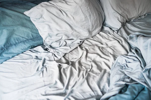 dağınık ve dağınık görünümlü, açık mavi yorgan ve çarşaflı kraliçe yatağı uykunuzu veya çift yaşam konseptinizi geliştirir.