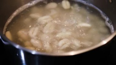 Patates gnocchi tuzlu su demliğinde kaynıyor. Basit, sağlıklı malzemeler kavramı.