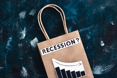 Ekonomide durgunluk ve durgunluk gösteren kavramsal imaj ile alışveriş torbası üzerinden metin ve büyüme istatistiklerinin azaldığını gösteren grafikler