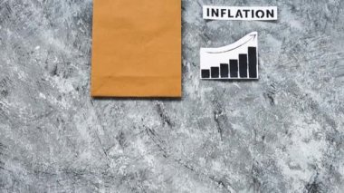 Enflasyon ve durağan ekonomi kavramsal imajıyla alışveriş torbası üzerinde fiyatların yükseldiğini gösteren grafiklerle