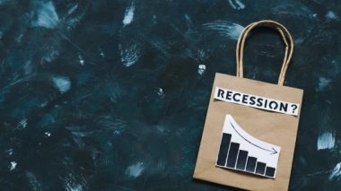 Ekonomide durgunluk ve durgunluk gösteren kavramsal imaj ile alışveriş torbası üzerinden metin ve büyüme istatistiklerinin azaldığını gösteren grafikler