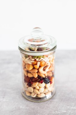 Cam kavanoz karışık fındık, badem, fıstık ve fıstık, doğal sağlıklı kiler malzemesi kavramı.