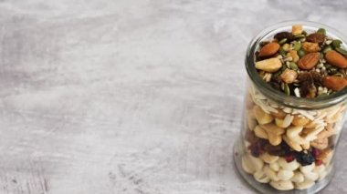 Cam kavanoz karışık fındık, badem, fıstık ve fıstık, doğal sağlıklı kiler malzemesi kavramı.