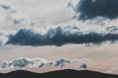 Fırtına bulutları Tazmanya, Avustralya tepeleri üzerinde kış gökyüzü boyunca gelip gidiyorlar.