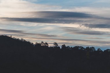 Tazmanya, Avustralya tepelerinde kış gökyüzü boyunca gelen ve giden bulutlar.
