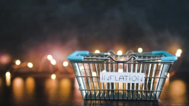 Ekonomi, kavramsal imajdan sonra enflasyon metni, boş alışveriş sepeti üzerine karanlık arkaplan ve ışık