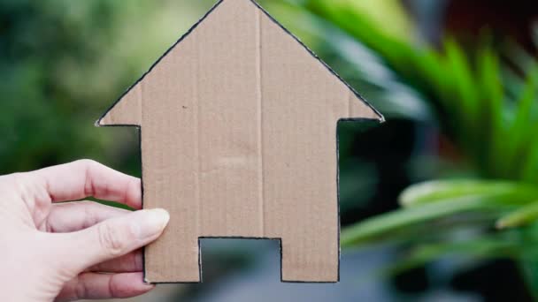 手握房屋图标在后院摆设 概念买房子和房地产市场或梦想的家或家庭生活 — 图库视频影像