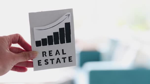 Hand Holding Real Estate Sign Graph Showing Stats Going Front — Vídeo de stock