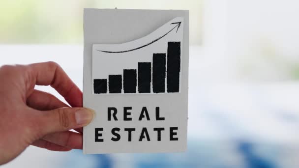 Hand Holding Real Estate Sign Graph Showing Stats Going Front — ストック動画
