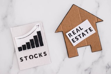 investment opportunities and building wealth conceptual image, house icon next to stock market stats symbol of alternative financial choices clipart
