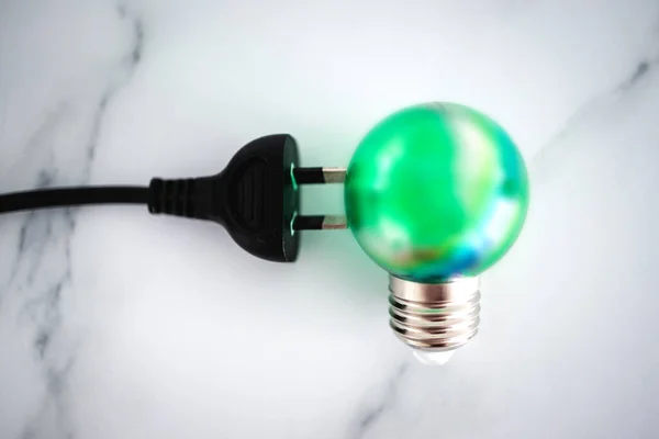 concept of clean green energy, electric plug next to green lightbulb