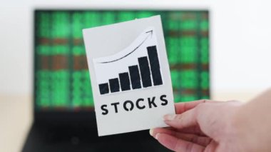 concept of trading stocks online, chart with Stock text in front of computer screen with financal markets results