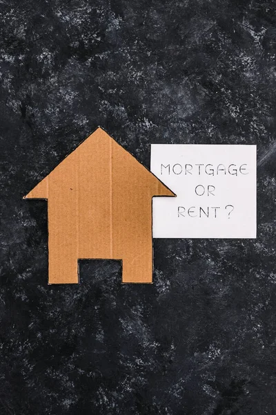 house icon next to mortgage or rent sign on dark background, concept of real estate affordability and property market