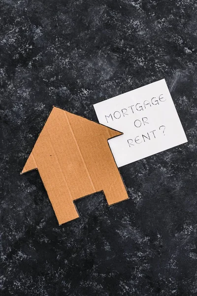 house icon next to mortgage or rent sign on dark background, concept of real estate affordability and property market
