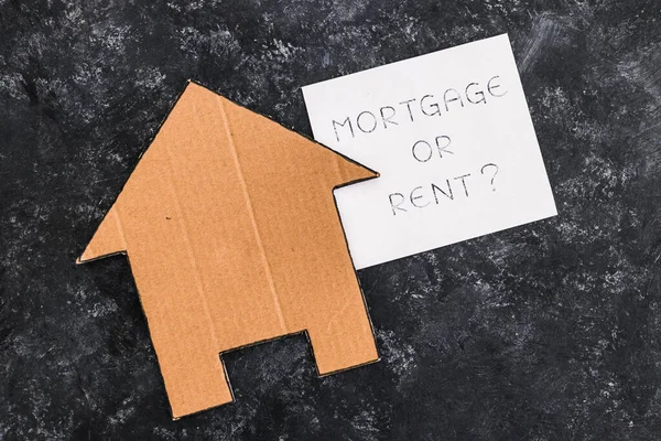 house icon next to mortgage or rent sign on dark background, concept of real estate affordability and property market