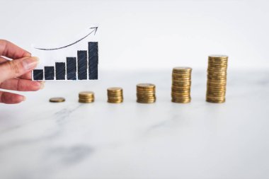 rising inflation graph in front of growing stacks of coins representing increasingly expensive prices, concept of global economy struggling after the covid-19 pandemic