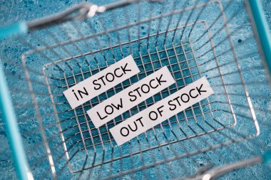 In stock, low stock and out of stock texts inside of empty shopping basket, concept of supply chain shortages and delays after the covid-19 global pandemic