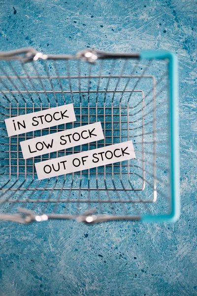 In stock, low stock and out of stock texts inside of empty shopping basket, concept of supply chain shortages and delays after the covid-19 global pandemic