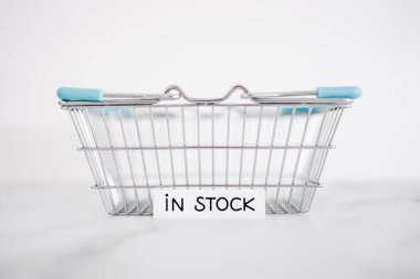 In stock text inside of shopping basket, concept of shopping and retail