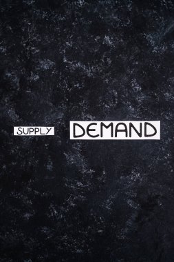 small Supply text and big Demand text on dark background, concept of supply chain shortages and delays after the covid-19 global pandemic