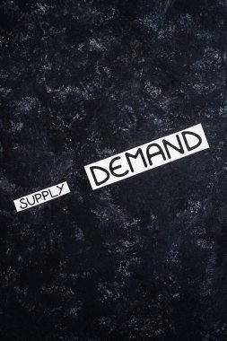 small Supply text and big Demand text on dark background, concept of supply chain shortages and delays after the covid-19 global pandemic