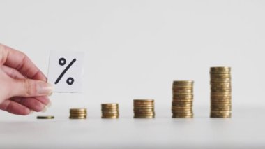 interest rates for loans and mortgages going up conceptual image, percentage symbol with growing stacks of coins representing increasingly expensive cost of financing