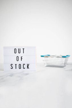 out of stock text on lightbox with empty shopping basket on white background, concept of supply chain shortages and delays after the covid-19 global pandemic