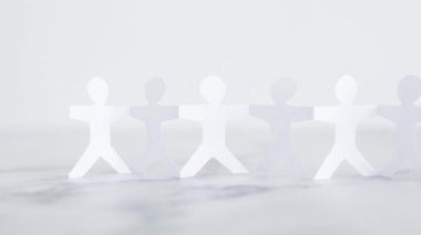 manpower and teamwork conceptual image, paper people chain with text on white marble background