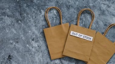 Out of Stock text on top of shopping bag, concept of supply chain shortages and delays after the covid-19 global pandemic