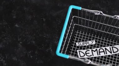 small Supply text and big Demand text inside of empty shopping basket, concept of supply chain shortages and delays after the covid-19 global pandemic