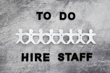 staff shortages and workforce conceptual image, To Do Hire Staff text with paper people chain and question marks on vacant positions to fill