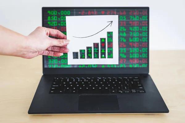 stock markets and financial investments concept, graph with positive growth stats in front of computer screen with financal markets results