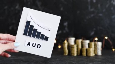 Döviz kuru kavramsal resim, grafik para yığınlarının önünde AUD AUstralian Doları metni ile negatif büyüme gösteriyor