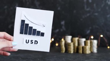 Döviz kuru kavramsal resim, para yığınlarının önünde ABD Doları metni ile negatif büyüme gösteren grafik