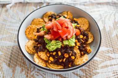 Mısır cipsli Meksika fasulyeli nachos ve domates sosu, sağlıklı vejetaryen yemek tarifleri.