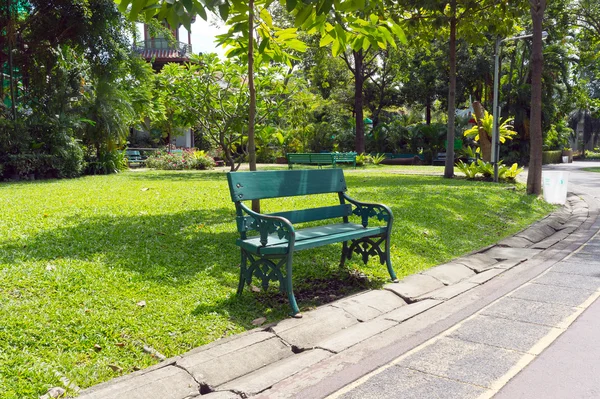 美丽自然的绿色花园的长椅上椅子 图库图片