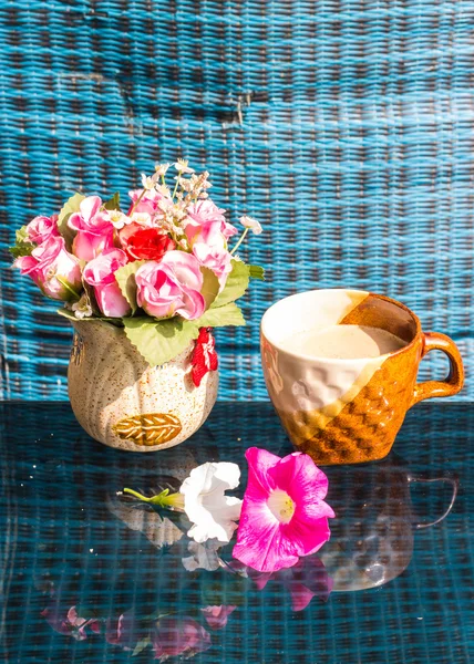 Bodegón, taza de café con flores de plástico rosa y petunia —  Fotos de Stock