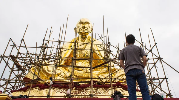 Uomo con Bodhisattva dorata Kru Ba Sri Vi Chai construction — Foto Stock