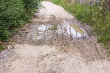 Kirli toprak yol su birikintileri ve çamur içinde kırsal Tayland ile