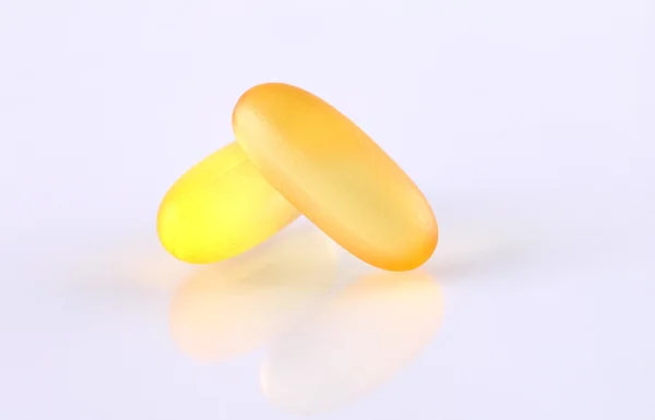 Transparent yellow fluid content medicine capsule on white backg — Stock Photo, Image