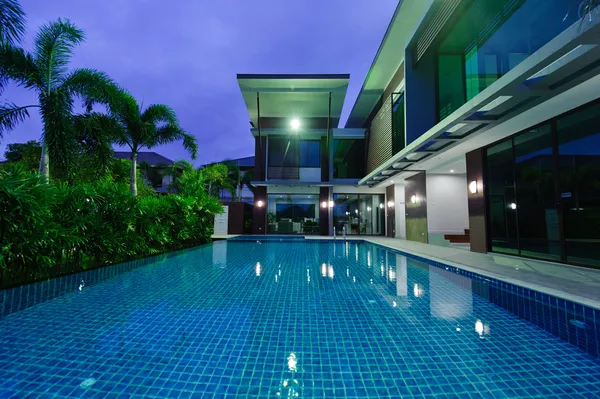 Casa moderna com piscina à noite — Fotografia de Stock