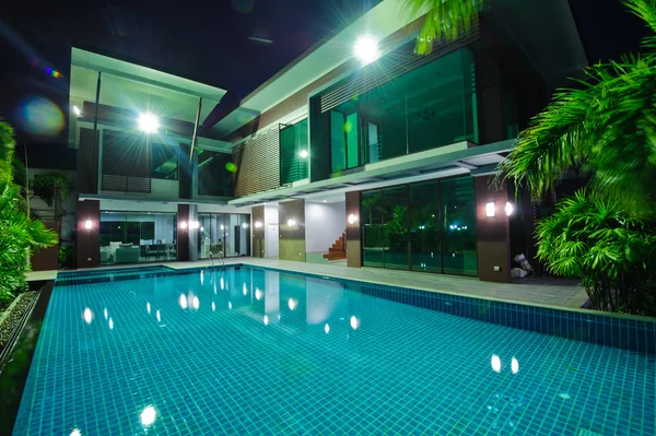 Современный дом с бассейном ночью — стоковое фото