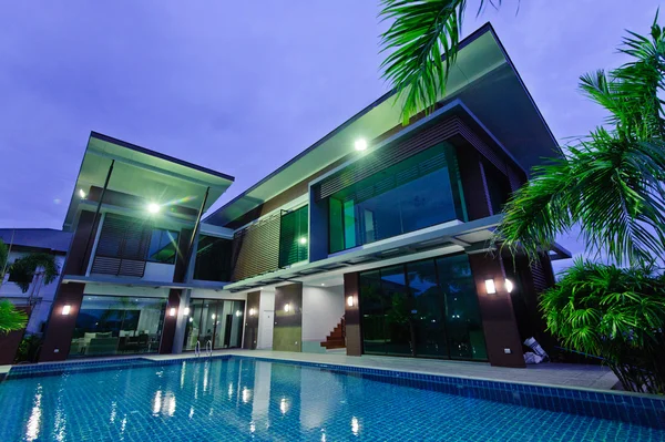 Moderna casa con piscina por la noche Imágenes de stock libres de derechos