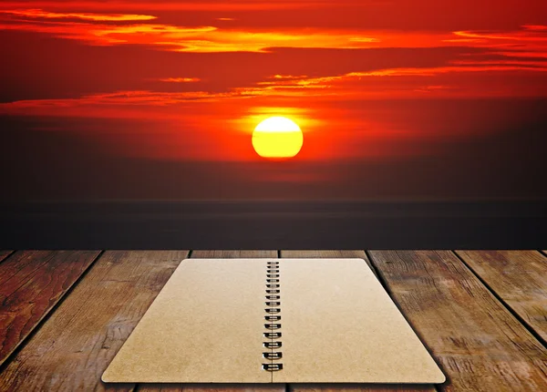 Livro no assoalho de madeira com por do sol — Fotografia de Stock