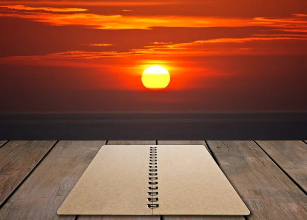 Livro no assoalho de madeira com por do sol — Fotografia de Stock