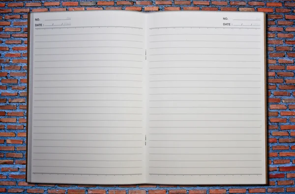 Caderno na parede de tijolos — Fotografia de Stock